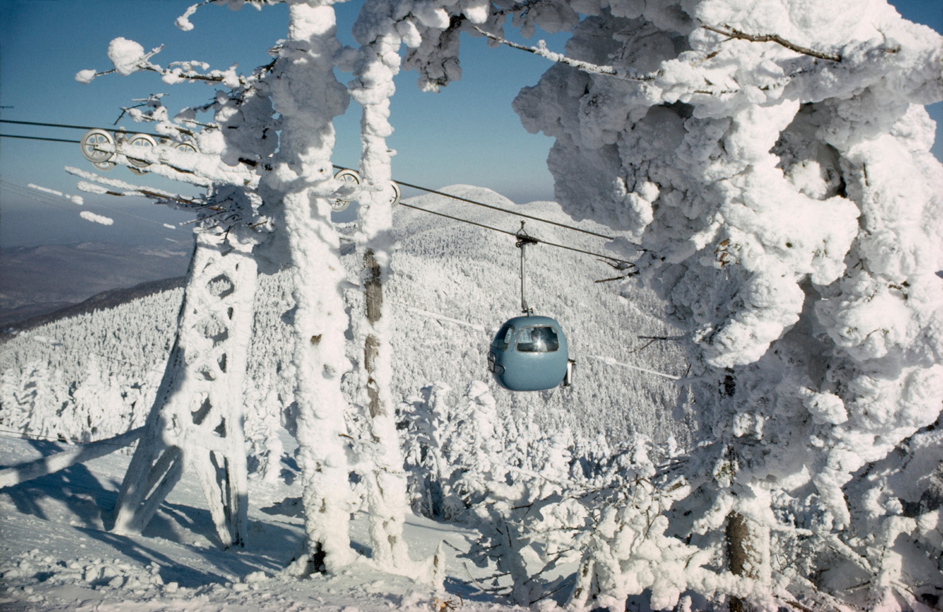 A gondola from Sugarbush Resort takes skiers to the top of a peak