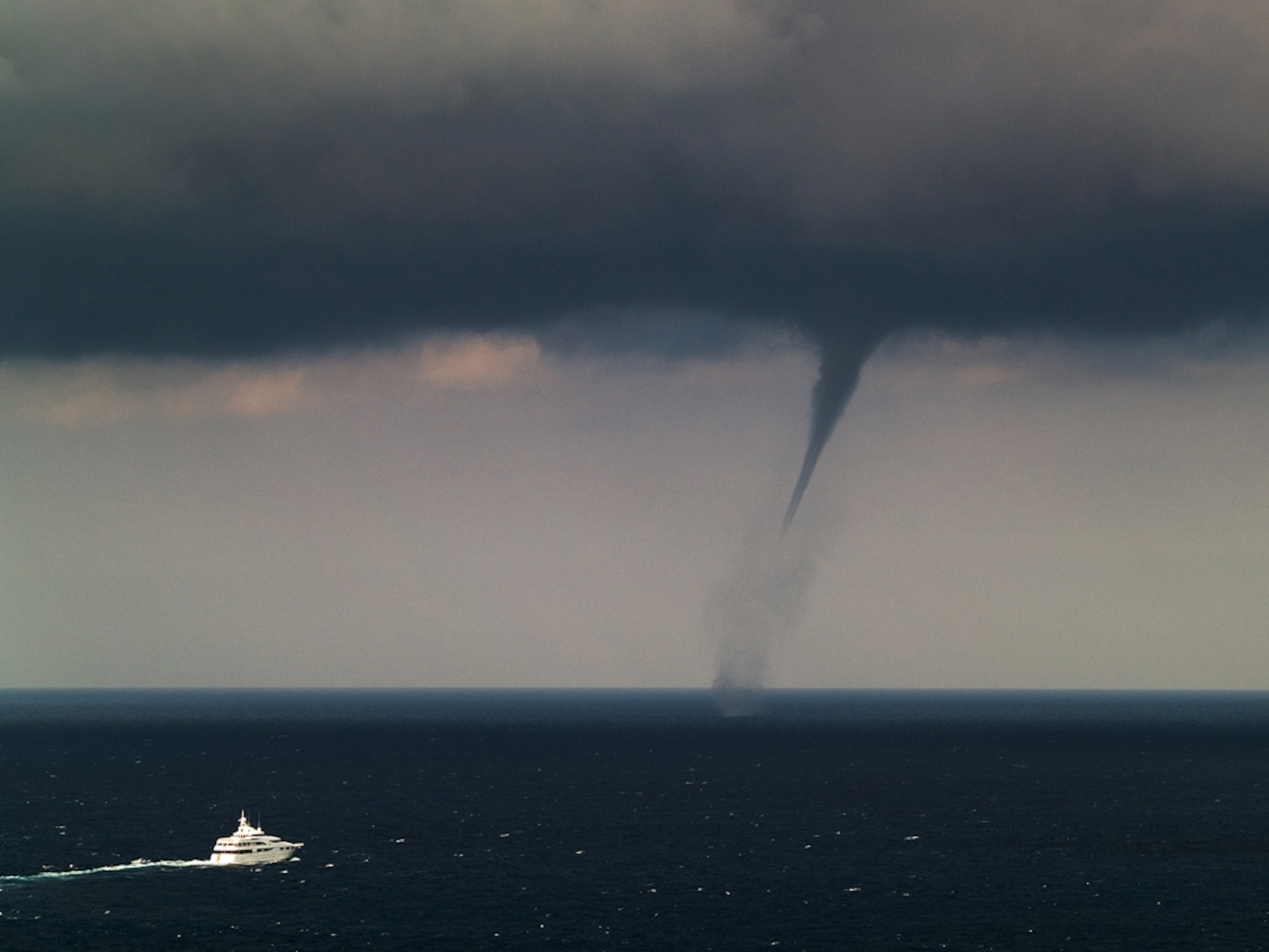 A ship with a waterspout in the background