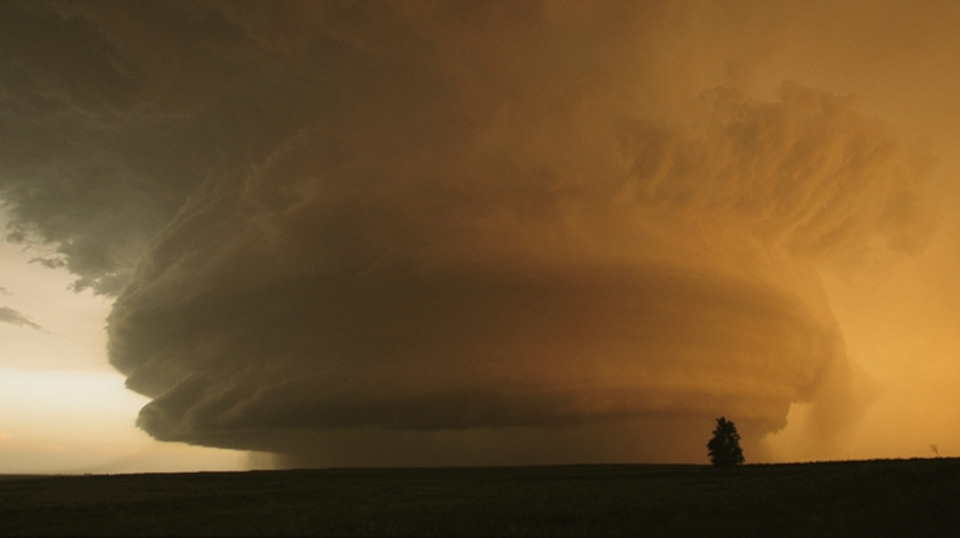 A large, orange-tinted, circular cloud formation