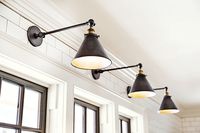 Metal library lights above the kitchen sink complement the black-painted windows. $169; Restoration Hardware