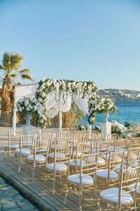 Holly and Ricci’s Lavish Mykonian seaside September affair in gold and white will tell you exactly that. Stylishly ensconced in Hippie Fish Mykonos the beautiful couple’s guests enjoyed a day filled with creamy luxury in all its shapes and sizes, from the all white and greenery ceremony on the deck right off the waterfront to the entire venue festooned with pasty florals, cream and gold accents, votives and crystal chandeliers it was all about glam meeting great times!