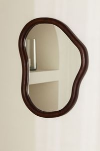 Large mirror in a mango wood frame with an asymmetric design. Medium-density fiberboard backing with mounting fixtures and option for hanging horizontally or vertically. Size 13 3/4 x 17 3/4 in.