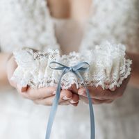 Just the right amount of fancy!Soft, delicate with a touch of sophistication for the bride who is juuuust a little bit fancy and looking for that extra something, something! Our 'Mrs. Fancy Pants' style wedding garter heirloom is designed with beautifully feminine textured ivory lace and detailed with a perfectly petite something blue bow. Details Production Shipping Sizing Main Garter: Light ivory satin background with two layers of scalloped ivory lace with a dusty blue satin bow with long tai