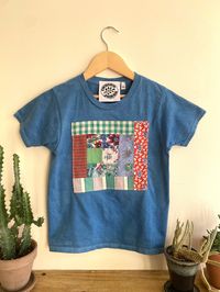 Hand dyed in indigo these kid's t-shirts are gender neutral and one of a kind, each with a unique patchwork appliqué made from power clashing vintage textiles.