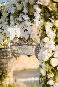 A luxury destination wedding in Mykonos with white flowers and greenery. The gold details and the crystal chandeliers match perfectly with the beautiful scenery.