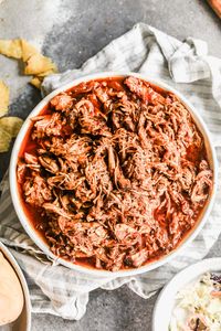 An easy slow cooker pulled pork shoulder recipe with homemade BBQ sauce and slaw. It's the BEST slow cooker pulled pork for a crowd!