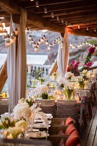 A luxury destination wedding in Mykonos with white flowers and greenery. The gold details and the crystal chandeliers match perfectly with the beautiful scenery.