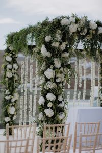 On an early summer weekend in May, guests gathered at the sunset terrace of the Royal Myconian hotel overlooking the Aegean Sea for the couple’s wedding ceremony. There, underneath a chuppah made of a mixture of white roses, peonies, olive branches, and greenery. After their first kiss, friends and family threw olive branch leaves.