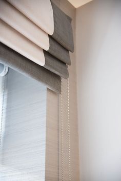 a close up of a window with blinds in the corner and a chain hanging from the side