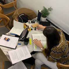 a woman sitting at a table with books and papers