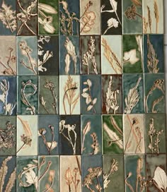 an assortment of flowers and leaves painted on ceramic tiles