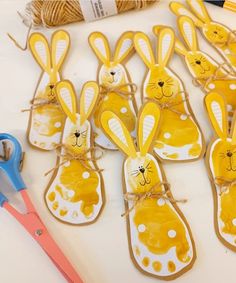 some bunny shaped cookies are sitting on a table next to scissors and twine string