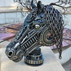 a metal horse head with chains attached to it's face on a table outside