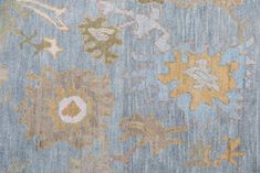 an old blue and yellow rug with flowers on it