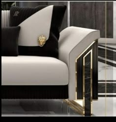 a black and white couch with a gold lion head on the armrest in front of it