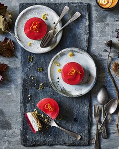 two desserts with red frosting and gold letters on them are sitting on plates