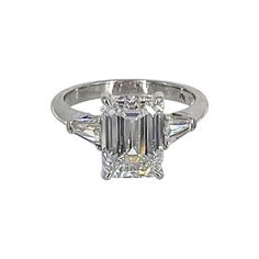 an emerald cut diamond ring with three baguets