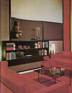 a living room filled with furniture and bookshelves next to a wall mounted book shelf