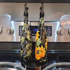 two vases with flowers on them are sitting in front of the stove top oven