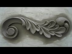 an intricately carved wall decoration on the side of a building with leaves and swirls