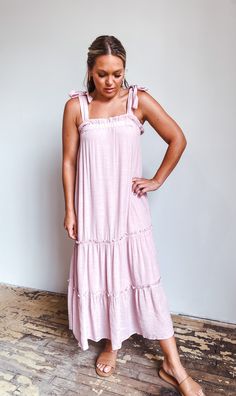 Up your Summer style game with this fab maxi dress! Irresistibly chic with its tiered design, ruffle neckline, and tie-shoulder detail, this babydoll style dress will help you stand out on even the hottest days. And what better color to show off in than lilac? Get ready to rock the beach in style! Feminine Maxi Dress With Tie Straps, Pink Maxi Dress With Ruffled Straps For Vacation, Pink Tiered Dress With Ruffled Straps For Summer, Casual Summer Tiered Maxi Dress, Flowy Dresses With Tie And Ruffled Straps, Casual Tiered Dress With Adjustable Straps, Flowy Tiered Dress With Ruffled Straps For Spring, Flowy Tiered Dress With Ruffled Straps, Casual Solid Color Maxi Dress With Ruffles