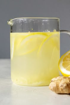 a glass pitcher filled with lemonade and ginger