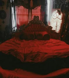 a bed with red sheets and pillows in a room