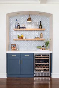 a kitchen with blue cabinets and shelves filled with wine bottles