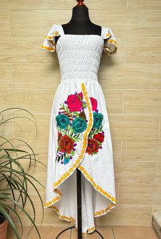 This beautiful dress is the perfect style to attend a Mexican party, with beautiful floral embroidery, has a spring at the waist to adjust the figure and a ducktail design. This dress is one size and fits S/M. Handcrafted machine embroidered dress. Each dress has unique embroidery so colors may vary. We ship anywhere in the word, from Tepic, Nayarit,  mx. Made by artisans from Oaxaca, Mx We recommend washing by hand with cold water, tender in the shade, to better preserve the original color. Fitted High-low Midi Dress For Summer, Floral Embroidered Midi Summer Dress, Floral Embroidered Midi Dress For Summer, Summer Floral Embroidery Midi Dress, Summer Floral Printed Knee-length Embroidered Dress, Multicolor Embroidered Midi Summer Dress, Floral Embroidered Knee-length Summer Dresses, Multicolor Embroidered Midi Dress For Summer, Spring Sleeveless Dress With Embroidered Hem