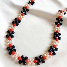 This elegant Coral, Pearl and Jade Necklace is the perfect accessory for any occasion. Delicately crafted with black jade, red coral, and freshwater pearls, this unique piece of jewelry is an eye-catching touch of sophistication to your look today! Black Jade (5mm) Red Coral (5mm) Freshwater Pearls (4mm) Goldfilled clasp Length: 15" Black Pearl Necklace With Round Beads As Gift, Elegant Red Pearl Necklace With Gemstone Beads, Elegant Red Beaded Pearl Necklace, Elegant Red Coral Necklaces With Polished Beads, Elegant Beaded Red Coral Pearl Necklace, Elegant Red Coral Beaded Pearl Necklace, Elegant Red Pearl Necklace With Natural Stones, Black Beads Pearl Necklace Gift, Elegant Red Coral Round Bead Necklaces