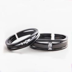 two black rings with diamonds on them sitting next to each other