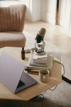 a laptop computer sitting on top of a wooden table next to a microscope and other items