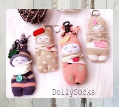 four little stuffed animals are hanging from keychains on a white background with the words dolly socks written below them