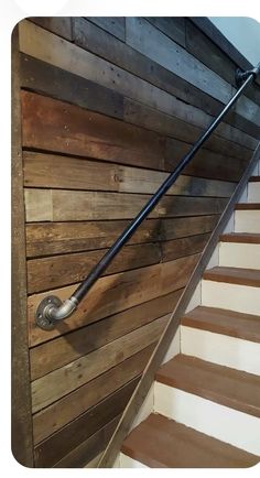 a stair rail on the side of a wooden wall