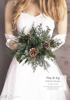 a woman in a white dress holding a bouquet of greenery and pineconis