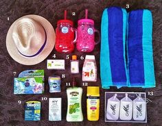 the contents of a travel bag laid out on a bed with towels, sunscreens, and other items