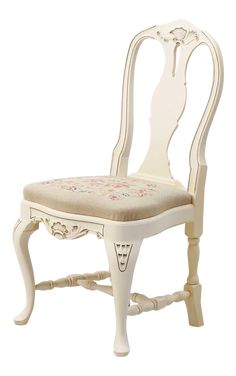 a white chair with a flowered seat cushion on it's back and legs