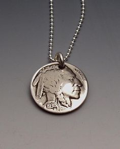 Pendant made from a vintage American Buffalo Nickel coin (the Indian is on the reverse side of the Buffalo, and the Indian is the front of this pendant). Year may vary. This pendant comes on a sterling silver bead chain. Please select length from the drop-down menu. Thanks for looking. Enjoy! Antique Sterling Silver Coin Necklace With Round Pendant, Nickel-free Sterling Silver Medallion Necklace, Collectible Sterling Silver Coin Necklace With Round Pendant, Symbolic Coin-shaped Nickel-free Necklace, Symbolic Nickel-free Coin Necklace, Symbolic Nickel-free Coin Necklaces, Symbolic Coin Shaped Nickel Free Necklace, Sterling Silver Coin Medallion Necklace Nickel Free, Silver Etched Coin Necklace