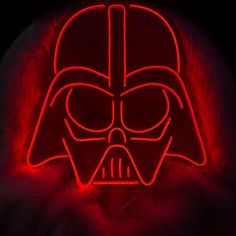 a darth vader mask is lit up in red and black light with fur around it