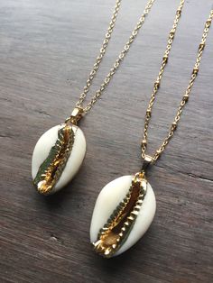 Cowrie Shell Necklace. This real cowrie shell has been dipped in 18k gold. It dangles from a gold-filled chain in your choice of a simple link or satellite chain. Wear it alone or layered for a great boho look. Matching bracelet available: https://www.etsy.com/listing/618535410/cowrie-shell-bracelet-adjustable?ref=shop_home_active_1 Matching earrings available here: https://www.etsy.com/listing/641824355/cowrie-shell-earrings-gold-cowrie-shell?ref=shop_home_active_2 Your cowrie shell necklace wi Boho Necklace Layering, Gold Shell Necklace, Beaded Diy, Silver Aesthetic, Cowrie Shell Necklace, Ocean Style, Necklace Shell, Cute Headphones, Cowry Shell