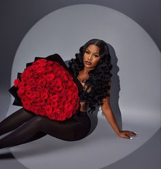 a woman in tights holding a large bouquet of red roses on her chest and legs