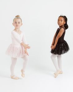 two young ballerinas posing for the camera in their tutu and leotards