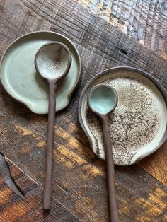 three spoons and two plates on a wooden table