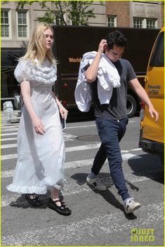 a man and woman walking across a street