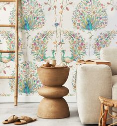 a living room with wallpaper and furniture in front of a chair, footstool and ladder