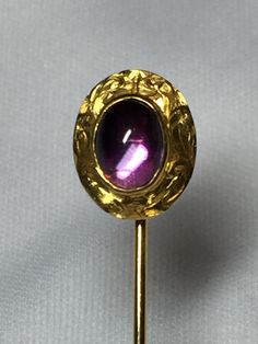 Vintage Cabochon Amethyst Stickpin in a 14K gold chased frame. Gorgeous color Amethyst stone. 9x6 Bezel Set. #9387 etched for Estate Date in underside. Stickpin weighs 1.6 Grams Stickpin is 2 1/4 inches in length. Pin head is 1/2 inches in length and 1/2 inches wide. Conversion to a ring available. Add $75.00 to price. You will receive finished produce in 1 week time. Antique 14k Gold Amethyst Ring, Classic Gold Gemstone Cabochons, Oval Yellow Gold Cabochons For Formal Events, Antique Gold 14k Gold Amethyst Ring, Classic Yellow Gold Cabochons For Formal Occasions, Antique Gold Amethyst Ring In 14k Gold, Formal Purple Cabochon Amethyst Ring, Elegant Yellow Gold Cabochons For Wedding, Classic Gold Cabochons For Gifts