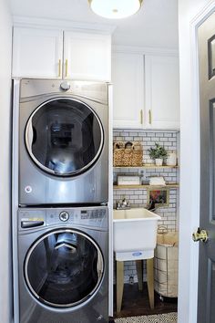 a washer and dryer in a small room next to a kitchen with white cabinets