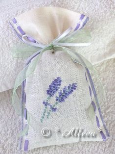 a cross stitch lavender flower on a white towel