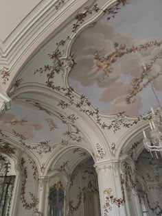 the ceiling is decorated with flowers and other designs on it, along with chandeliers