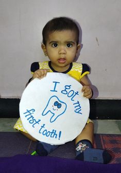 a little boy holding up a sign that says i got my teeth on the plate